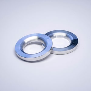 以下が含まれることがあります： 白い背景に、メタリックブルーとシルバーの2つのリングが表示されています。 リングは、面取りされたエッジと研磨された仕上げの円形です。 これらは、コンポーネントまたは装飾要素である可能性があります。
