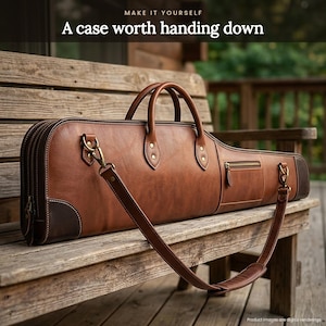 May include: A brown leather long gun case with two top handles, a detachable shoulder strap, and a small zippered side pocket. The case features dark brown leather corner reinforcements, brass-toned hardware, and the text MAKE IT YOURSELF A case worth handing down.