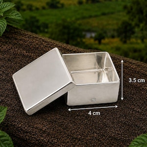May include: A square silver box with a removable lid, featuring a 925 hallmark stamp on the front side. The box measures 4 cm in width and 3.5 cm in height as indicated by the visible measurement markers on the object itself.