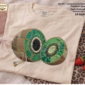 Puede incluir: Una camiseta beige con un diseño bordado detallado de un kiwi cortado por la mitad. Las mitades de kiwi son verdes con patrones intrincados, cuentas tipo perla y un centro negro. El texto en la camiseta dice "300 DPI - Transparent Background, Premium Quality, Faux Embroidery, Commercial use, 14 inch" (aproximadamente 36 cm).