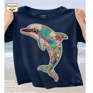 May include: Navy blue t-shirt featuring a colorful dolphin design. The dolphin is decorated with various sea-themed elements, including seashells, seahorses, and tropical flowers. The shirt has a crew neck and short sleeves. The dolphin design is approximately 14 inches.