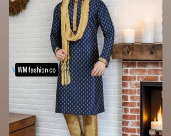 May include: A navy blue kurta pajama set with a gold scarf. The kurta features a subtle diamond pattern and gold trim. The matching pants are gold. The outfit is worn with gold shoes. The text "WM fashion co" is visible.