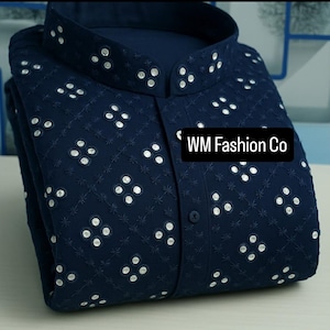 Puede incluir: Camisa azul marino con cuello mao y bordados blancos. Presenta un patrón repetitivo de adornos circulares blancos y el texto "WM Fashion Co".