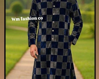 May include: A long, checked coat in navy blue and grey. The coat features a mandarin collar and is fastened with buttons. The text "Wm fashion co" is visible. The coat is worn by a person standing on a stone path, with a garden in the background.