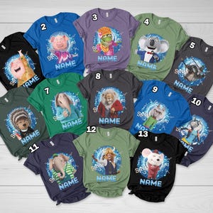 May include: A collection of colorful t-shirts featuring characters from the animated movie "Sing". Each shirt displays a different character with the word "NAME" below. The shirts are in various colors, including black, blue, green, and gray.