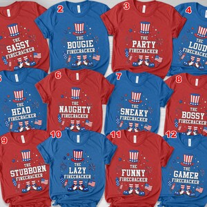 May include: A collection of red and blue t-shirts with various phrases and graphics related to fireworks. Each shirt features a patriotic design with an Uncle Sam hat and the words "The Sassy Firecracker", "The Bougie Firecracker", and more.