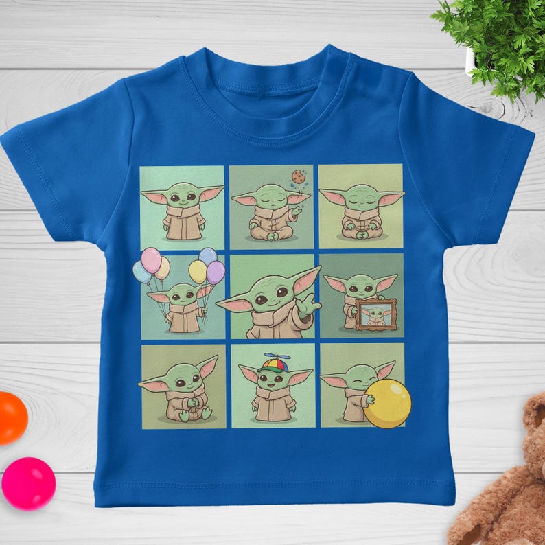 May include: A blue t-shirt with a grid of nine illustrations of a green alien character. Each illustration shows the character in different poses, some holding balloons, a cookie, or a yellow ball. The shirt is made of a soft material.