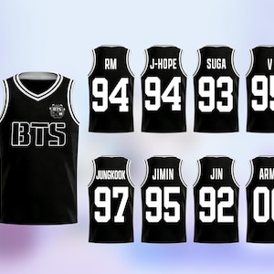 May include: Black basketball-style jerseys with white trim and lettering. The jerseys feature the text "BTS" and various names and numbers, including "RM 94", "J-HOPE 94", "SUGA 93", and "V 95".