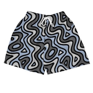 May include: A pair of shorts with a wavy, abstract pattern in shades of gray, black, and light blue. The shorts have a white drawstring and a relaxed fit. The design includes triangles and organic shapes.