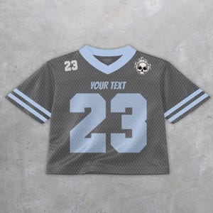 May include: Gray mesh crop top jersey with light blue accents. Features the number 23 in light blue on the front and a skull graphic. Includes the text "YOUR TEXT" above the number.