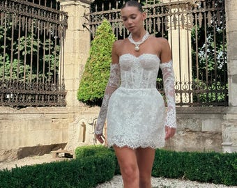 取り外し可能な袖が付いたレースの白いショートコルセットウェディングドレス。アフターパーティーや結婚式の写真撮影に最適なミニブライダルガウン。