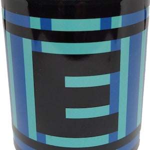 Könnte beinhalten: Schwarzes Schnapsglas mit einem pixeligen Design in Blau- und Türkistönen. Das Design zeigt einen großen Buchstaben "E" im Retro-Videospiel-Stil. Die oberen und unteren Ränder sind schwarz.