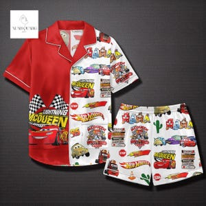 A red pajama set featuring various car-themed designs, including Lightning McQueen, Hot Wheels, and other popular car logos. The pajama set is displayed against a dark background.
