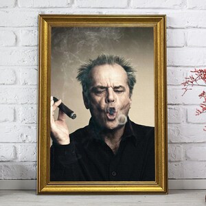 Könnte beinhalten: Gerahmtes Porträt eines Mannes, der eine Zigarre raucht, mit Rauch um sein Gesicht. Das Porträt befindet sich in einem goldenen Rahmen und lehnt an einer weißen Backsteinmauer. Eine Vintage-Kamera und eine Vase mit roten Blumen sind ebenfalls vorhanden.