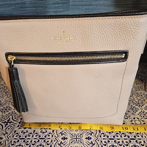 Kate Spade Chester street crossbody in taupe and black with a tassell in excellent condition. Free Shipping in the US.