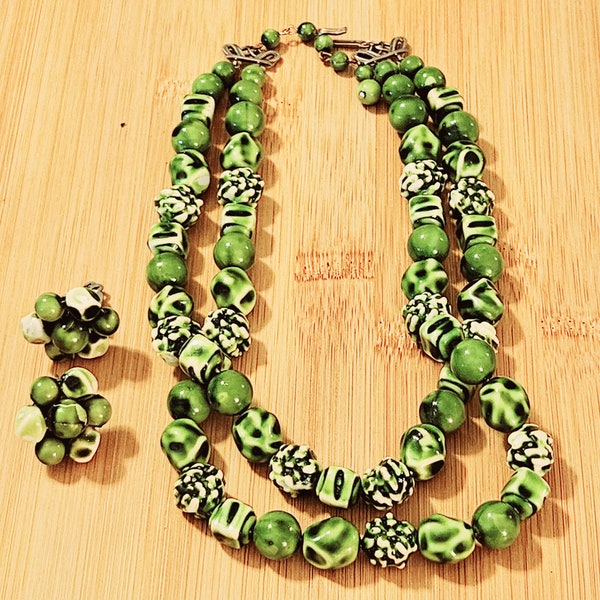 Collier vintage à deux rangs dans diverses nuances de vert avec boucles d'oreilles assorties à clip sur une grappe. L'époque semble être les années 1950-1960.