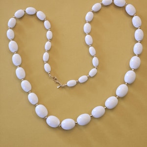 Vintage Monet signature necklace in white graduated beads in very good Vintage condition.