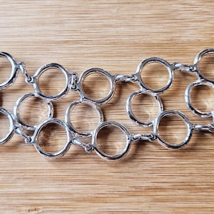 Bracciale rigido vintage leggero di Sarah Coventry con motivi circolari, in eccellenti condizioni vintage!