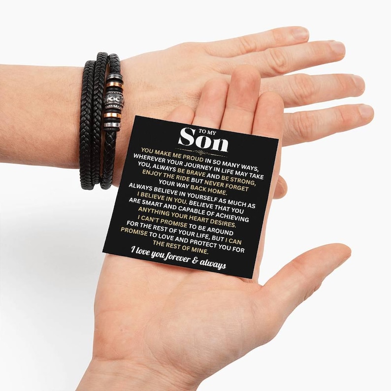 May include: Black braided leather bracelet with silver and copper-colored beads. A black card held in a hand reads "TO MY Son" with a loving message. The bracelet is a thoughtful gift.
