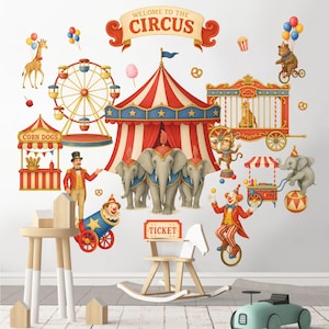 May include: A colorful circus-themed wall decal set featuring a red and white striped big top tent, elephants, a Ferris wheel, and various circus performers. The words "WELCOME TO THE CIRCUS" are displayed on a banner.