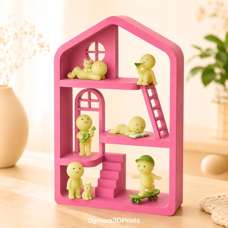 May include: A vibrant pink, house-shaped shelf unit with several levels, populated by small yellow figures. The figures are depicted in different poses, such as playing a guitar, skateboarding, and reading. A cat figurine is also included. The text "Dymora3DPrints" is visible.