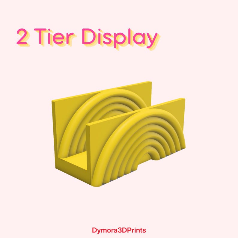 K&ouml;nnte beinhalten: Gelbes 2-st&ouml;ckiges Display mit Regenbogen-Design. Das Display hat eine rechteckige Basis und zwei aufrechte Abschnitte mit gebogenen, halbkreisf&ouml;rmigen Rillen. Der Text "2 Tier Display" steht oben.