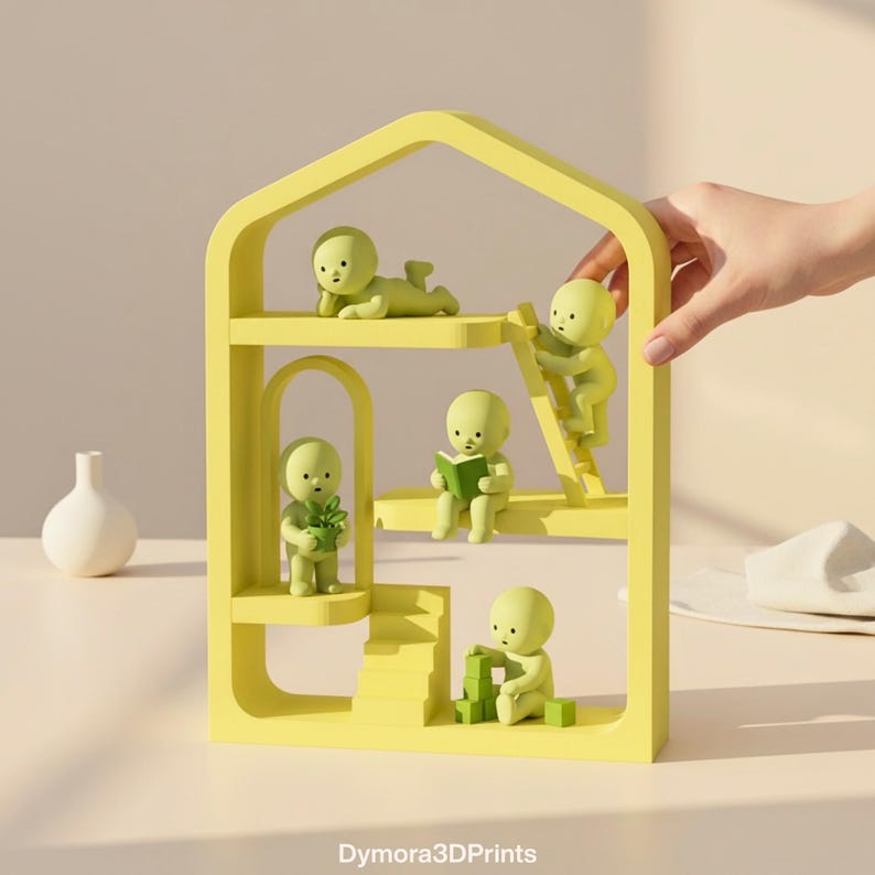 May include: A yellow, multi-tiered decorative shelf shaped like a house, featuring small green figurines in various poses. One figurine is reading a book, another is climbing a ladder, and others are interacting with blocks and plants. The shelf has an arched doorway.