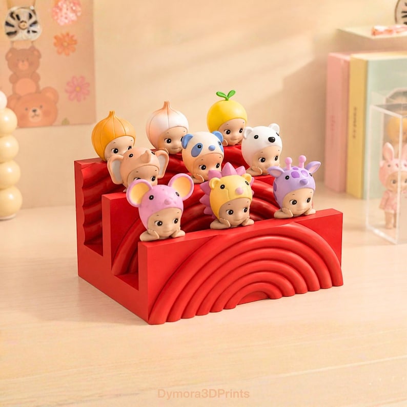 K&ouml;nnte beinhalten: Ein roter dekorativer Display-St&auml;nder h&auml;lt neun kleine Figuren, jede mit einem anderen Tierhut. Die Figuren sind in drei Reihen angeordnet. Zu den H&uuml;ten geh&ouml;ren ein B&auml;r, eine Giraffe, eine Maus und ein Igel. Der St&auml;nder hat ein geschwungenes Design.