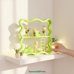 May include: A light green decorative shelf with a wavy design, holding small yellow figurines. The figurines are engaged in various activities, such as playing a guitar and reading. The shelf is on a white surface, with small plants and lights.