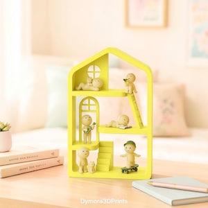 May include: A vibrant yellow house-shaped shelf unit with several levels, each displaying small figurines in different poses. One figurine is on a skateboard, another plays a guitar, and others are relaxing. The shelf is on a wooden surface.