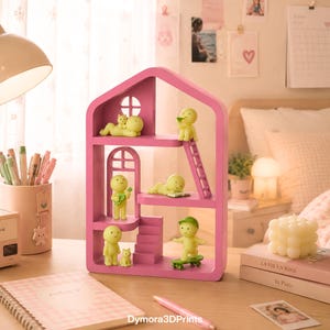 May include: A pink dollhouse-style shelf unit with several levels, windows, and a ladder. The shelf is decorated with small yellow figurines in various poses, including playing a guitar and skateboarding. A notebook and pen are on the desk.