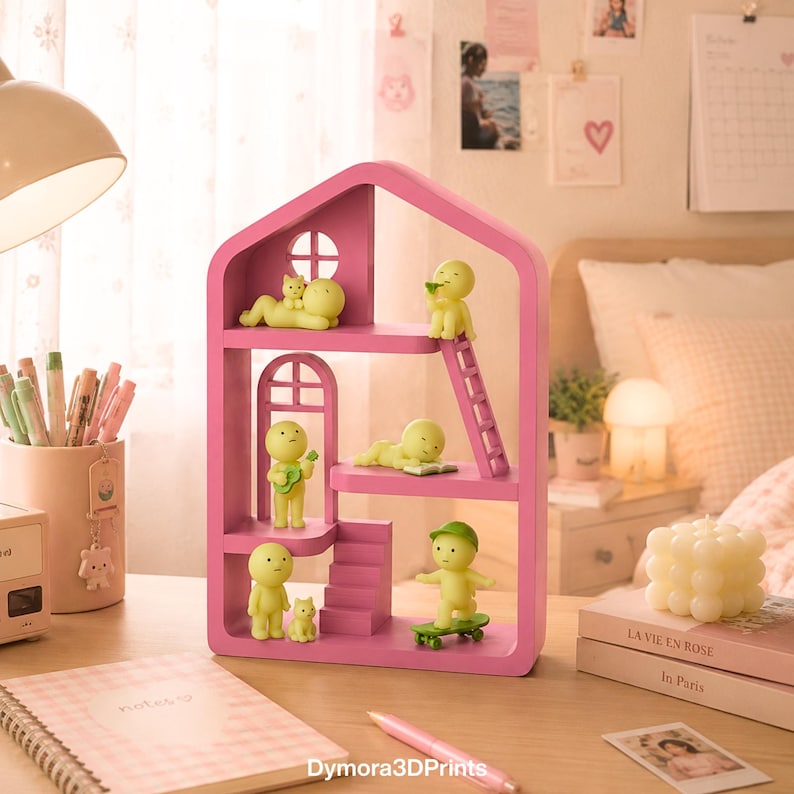 May include: A pink dollhouse-style shelf unit with several levels, windows, and a ladder. The shelf is decorated with small yellow figurines in various poses, including playing a guitar and skateboarding. A notebook and pen are on the desk.