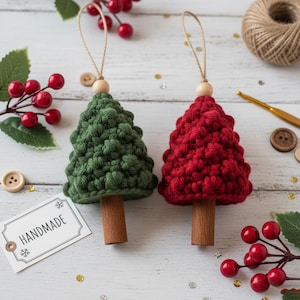 Peut inclure: Deux décorations de Noël faites à la main au crochet. L'une est verte, l'autre est rouge. Chaque arbre a un tronc en bois, une perle en bois en haut et une boucle en ficelle pour l'accrocher. L'étiquette indique "HANDMADE".