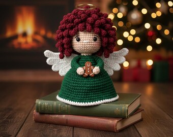 May include: A handmade crochet angel doll with a burgundy curly hair, a gold halo, and sparkly white wings. The doll wears a green dress and holds a gingerbread man. It is sitting on top of two vintage books.