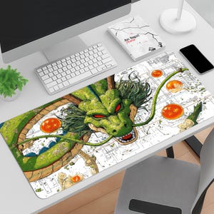 Puede incluir: Alfombrilla de escritorio rectangular con un dragón verde con ojos rojos y orbes naranjas. El dragón está sobre un fondo blanco con un diseño esquemático. La alfombrilla está diseñada para usarse con una computadora y un teclado.