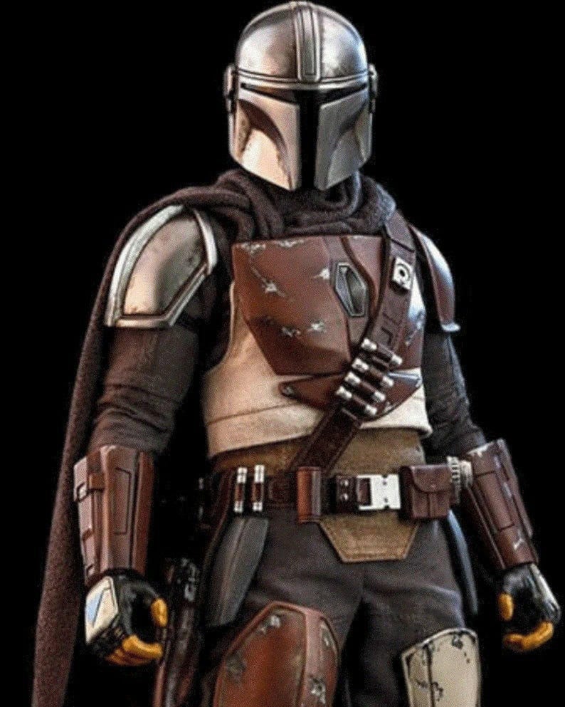 May include: A detailed action figure of a warrior wearing a metallic silver helmet, a brown chest plate with battle-worn scuffs, a dark brown cape, and a utility belt with pouches. The figure features brown arm guards, gloves, and leg armor.