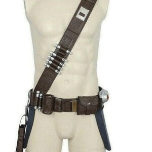 May include: A brown utility belt and shoulder strap set featuring a series of silver-toned cylindrical canisters attached to the strap and belt, a rectangular pouch, a holster, and a metallic buckle detail worn on a torso mannequin display.