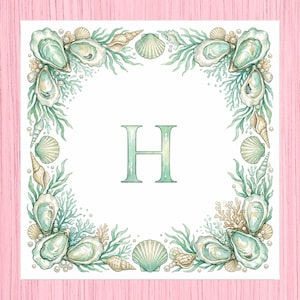 May include: Square watercolor print featuring a border of seashells, oysters, and seaweed in shades of green, beige, and white. The letter "H" is centered in a matching green hue. The background is white, with a pink wooden surface.