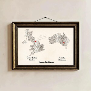 May include: Framed map art featuring Great Britain and Australia, with red heart markers on London and Melbourne. The map is composed of gray and white shapes, with the text "Home To Home" below. The frame is dark brown.