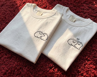 Camiseta bordada con una pareja de ranas que mordieron juguetonamente o abrazaron dulcemente. Camiseta con un adorable animalito, regalo divertido para San Valentín.