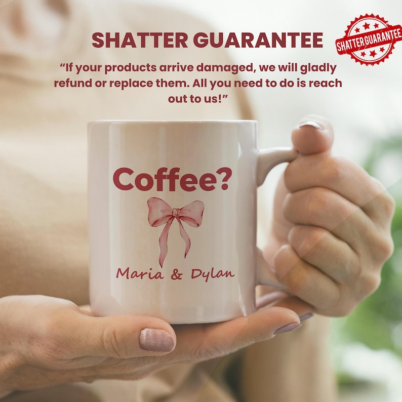 May include: White ceramic mug with the text "Coffee?" in burgundy, along with a burgundy bow graphic and the names "Maria & Dylan." The mug has a handle and is held by a person. The image also includes the text "SHATTER GUARANTEE."