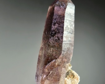 Punta de cuarzo ahumado con revestimiento de hematita, lepidolita y ortoclasa. Minas Gerais, Brasil.