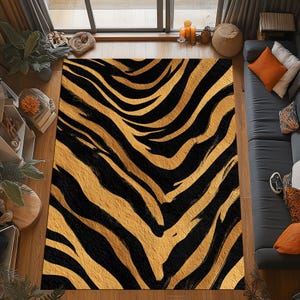 May include: A rectangular rug with a bold zebra stripe pattern in black and gold. The rug is placed on a wooden floor, with a sofa and window visible in the background. The rug's design adds a striking visual element to the room.