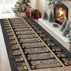 Puede incluir: Una alfombra rectangular con un dise&ntilde;o de v&iacute;a de tren. La alfombra presenta v&iacute;as plateadas paralelas, traviesas de madera y grava gris. La alfombra est&aacute; colocada sobre un suelo de madera de color claro, con un &aacute;rbol de Navidad y una chimenea al fondo.