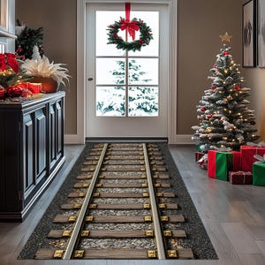 Puede incluir: Una alfombra rectangular con un dise&ntilde;o de v&iacute;a de tren. La alfombra presenta traviesas de madera, rieles met&aacute;licos y una base de grava. La escena est&aacute; ambientada en un hogar decorado con un &aacute;rbol de Navidad, regalos y una corona en la puerta.