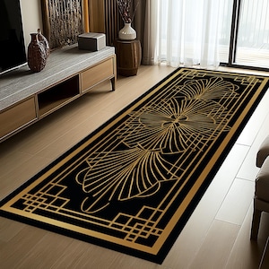 Può includere: Un tappeto rettangolare nero con un design art déco dorato. Il tappeto presenta un motivo centrale a forma di fiore e bordi geometrici. Il design dorato contrasta con lo sfondo nero. Il tappeto è posto su un pavimento in legno.