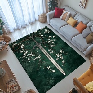 May include: A rectangular area rug with a dark green background featuring a detailed illustration of a silver sword, tree branches, and white flowers. The rug is designed to be placed on a floor.