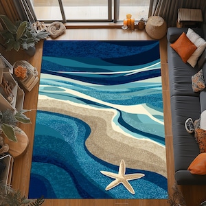 Può includere: Un tappeto rettangolare con un design a tema spiaggia. Presenta un oceano blu con onde bianche, una spiaggia sabbiosa e una stella marina. La tavolozza dei colori include sfumature di blu, beige e bianco.