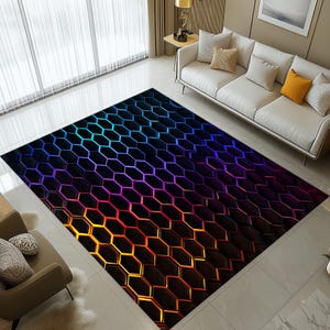 May include: A rectangular rug featuring a geometric honeycomb design. The colour scheme transitions from blue to purple and orange. The rug is placed on a tiled floor in a living room setting.