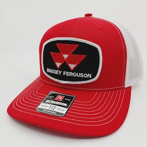 May include: Red and white trucker hat with the Massey Ferguson logo on the front. The logo is a black rectangle with a white border, featuring three red triangles and the words "MASSEY FERGUSON" in white. The hat is adjustable.